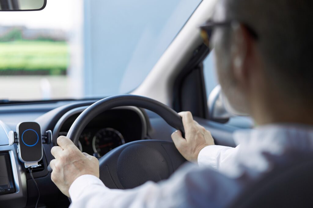 Back view of an elderly person driving a car